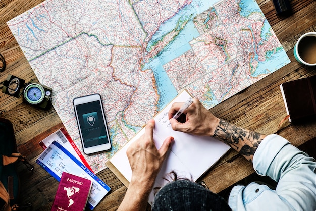 Vista aerea dell&#39;uomo che progetta la scrittura di viaggio sul taccuino