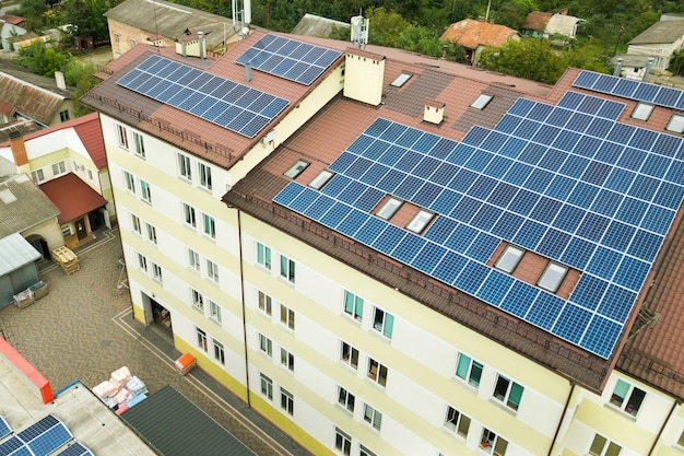 Vista aerea della centrale solare con pannelli fotovoltaici blu montati sul tetto del condominio