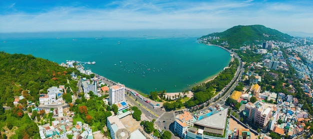 Vista aerea della città di Vung Tau con bel tramonto e tante barche Vista panoramica costiera di Vung Tau dall'alto con onde lungo la costa, alberi di cocco e montagna Tao Phung in Vietnam