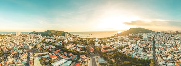 Vista aerea della città di Vung Tau con bel tramonto e tante barche Vista panoramica costiera di Vung Tau dall'alto con onde lungo la costa, alberi di cocco e montagna Tao Phung in Vietnam