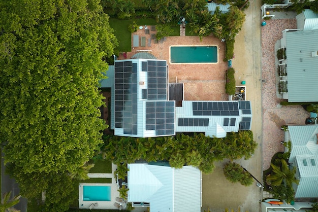 Vista aerea della costosa casa americana con piscina e tetto con pannelli fotovoltaici solari blu per la produzione di energia elettrica ecologica pulita Elettricità rinnovabile con concetto a zero emissioni