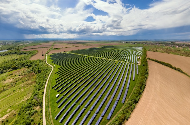 Vista aerea della grande centrale elettrica sostenibile con molte file di pannelli solari fotovoltaici.