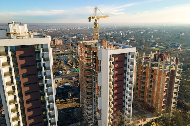 Vista aerea della gru a torre alta e dei condomini residenziali in costruzione. Sviluppo immobiliare.