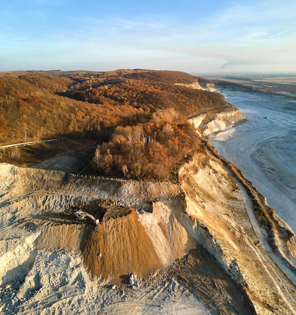 Vista aerea della miniera a cielo aperto di materiali di arenaria per l'industria edile con escavatori e autocarri con cassone ribaltabile Attrezzature pesanti nell'estrazione e produzione di minerali utili concept