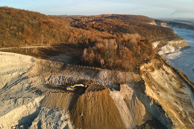 Vista aerea della miniera a cielo aperto di materiali in arenaria per l'edilizia con escavatori e autocarri con cassone ribaltabile. Attrezzature pesanti nell'estrazione mineraria e nella produzione di minerali utili concept