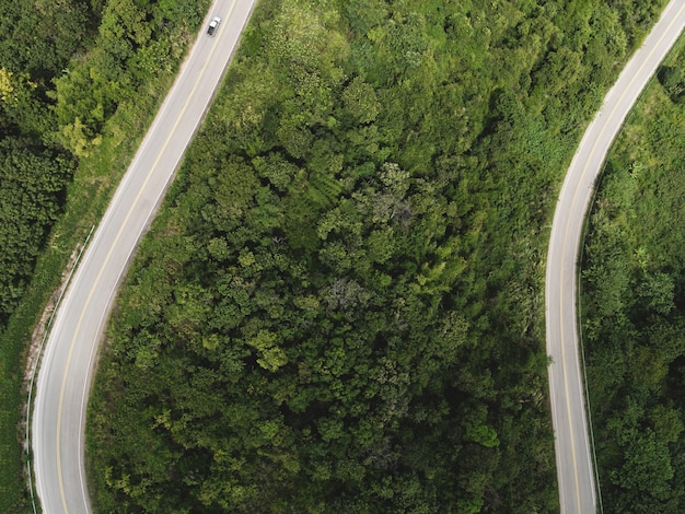 Vista aerea della natura della foresta con auto sulla strada sull'albero verde di montagna, curva stradale vista dall'alto dall'alto, vista a volo d'uccello strada attraverso la montagna la foresta verde bellissimo ambiente fresco