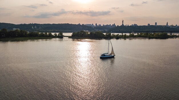 Vista aerea della navigazione dell'yacht nel fiume di Dnieper sul tramonto da sopra