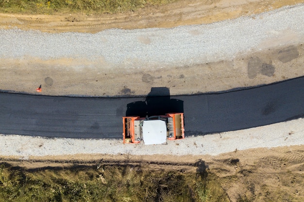 Vista aerea della nuova costruzione di strade con macchina a rulli a vapore al lavoro.