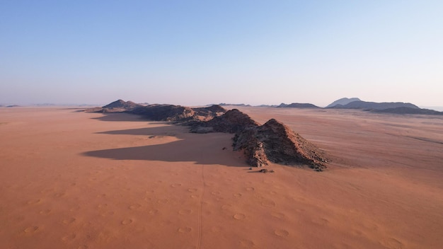 Vista aerea della sabbia del deserto e della catena montuosa immersa nella luce del primo mattino nella valle di Hartmans