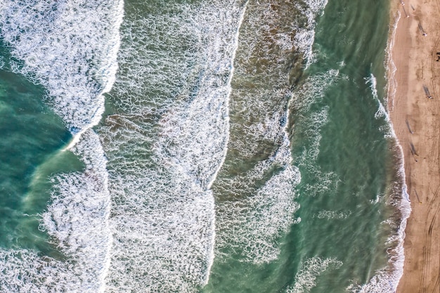 Vista aerea della spiaggia di sabbia con i turisti che nuotano nell'acqua del mare cristallino