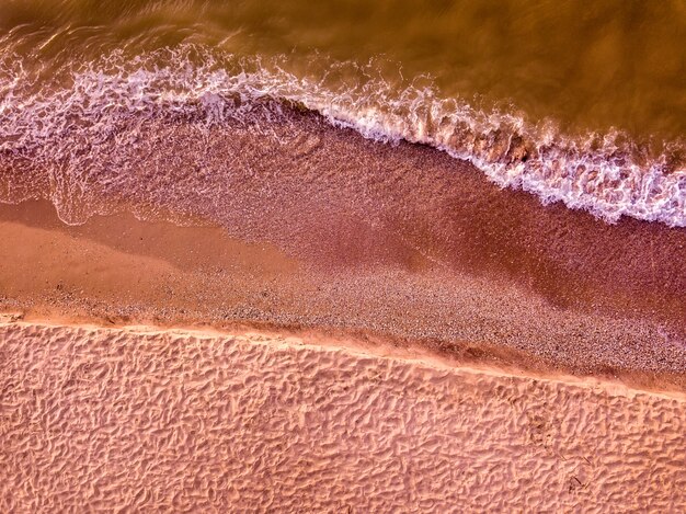 Vista aerea della spiaggia sabbiosa e del mare con le onde