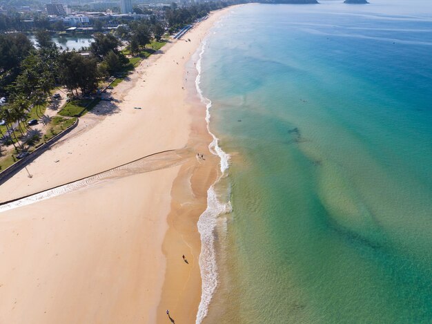 Vista aerea della splendida spiaggia con belle donne che camminano sulla spiaggia nella luce del tramonto vicino al mare turcheseVista dall'alto del paesaggio estivo della spiaggia Concetto di viaggio e tour per le vacanze