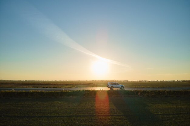 Vista aerea della strada interurbana con auto a guida veloce sfocata al tramonto. Vista dall'alto dal drone del traffico autostradale in serata.