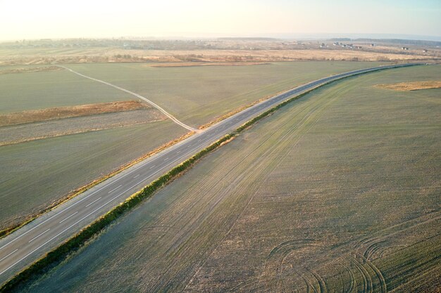 Vista aerea della strada interurbana vuota al tramonto. Vista dall'alto dal drone dell'autostrada in serata