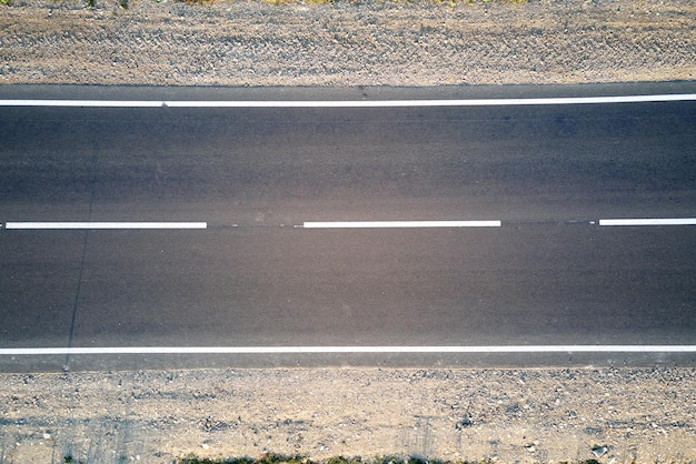 Vista aerea della strada interurbana vuota al tramonto. Vista dall'alto dal drone dell'autostrada in serata.