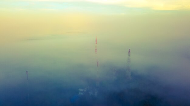 Vista aerea della torre di Telecom in cima alla montagna con nebbioso.