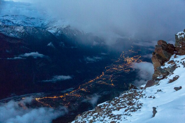 Vista aerea delle luci notturne della città nella valle della montagna