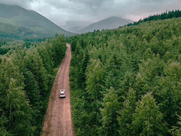 Vista aerea delle montagne dei Carpazi tempo nuvoloso suv auto sullo spazio della copia della strada del sentiero