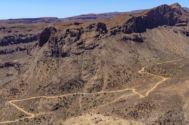 Vista aerea delle montagne di Gran Canaria con una strada che gira intorno alla collina facendo curve. Spagna. Europa.