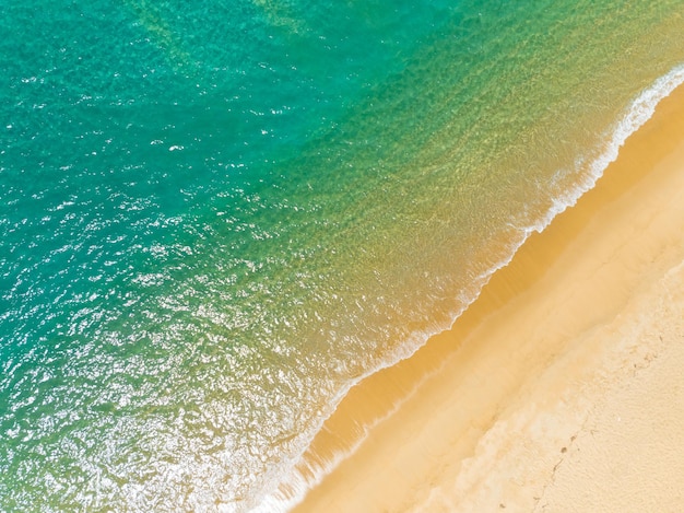 Vista aerea delle onde del mare che si infrangono Onde bianche schiumose sulla sabbia della spiaggia Vista superiore della spiaggia Vista del paesaggio marino Natura sfondo del mare