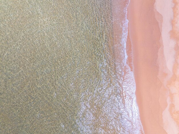 Vista aerea delle onde del mare che si schiantano onde bianche sulla sabbia della spiaggia vista superiore della superficie della spiaggia natura della spiaggia sfondo di sabbia della spiaggia