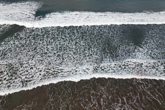 vista aerea delle onde sulla spiaggia. La schiuma bianca delle onde rompe le onde dell'oceano.