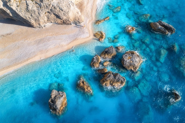 Vista aerea delle rocce del mare blu in acqua limpida spiaggia di sabbia bianca al tramonto in estate Isola di Porto Katsiki Lefkada Grecia Bellissimo paesaggio con pietre della costa del mare in onde di acqua azzurra Vista dall'alto