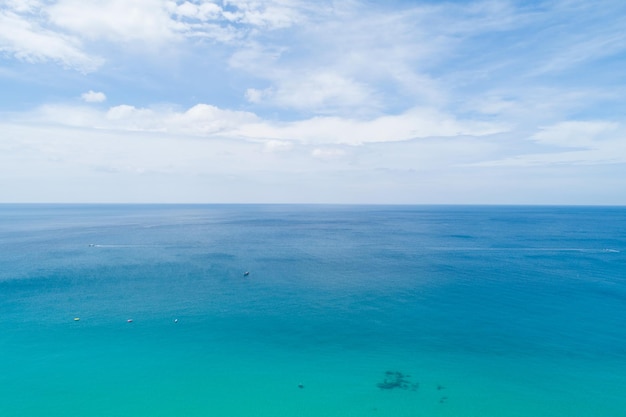 Vista aerea dello sfondo della trama dell'acqua della superficie del mare blu Drone che vola sul mare Trama della superficie dell'acqua delle onde sull'oceano tropicale soleggiato nell'isola di Phuket in Thailandia