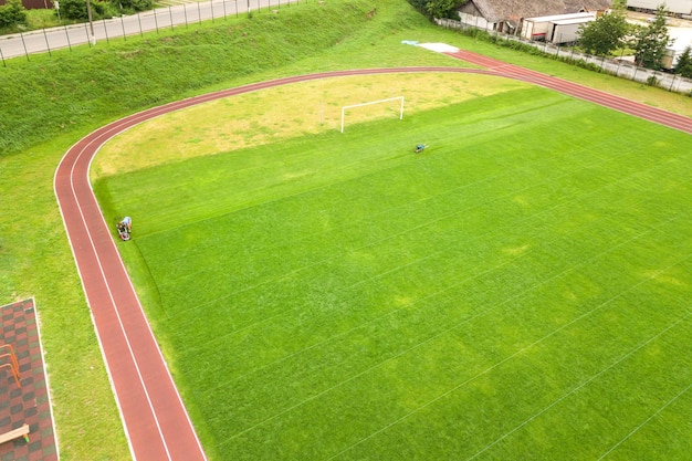 Vista aerea dello stadio sportivo con piste da corsa rosse e campo da calcio in erba verde.