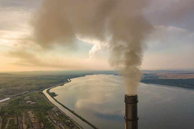 Vista aerea di alti tubi del camino con fumo grigio dalla centrale elettrica del carbone. Produzione di elettricità con combustibili fossili.