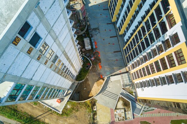 Vista aerea di alto edificio residenziale con numeri di piano sulla parete in costruzione. Sviluppo immobiliare.