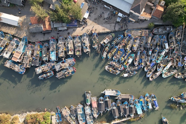 Vista aerea di barche da pesca ancorate al porto fluviale vicino al mare Pantai Widuri Indonesia