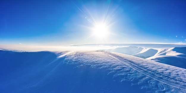 Vista aerea di bellissimi pendii montani invernali coperti di neve e foresta di abeti in una giornata di sole senza nuvole. Concetto di bellezza della stazione sciistica europea