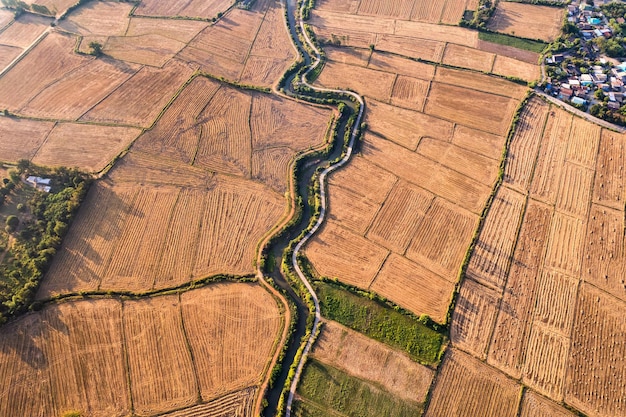 Vista aerea di campi sterili agricoli con canale di irrigazione in terreni agricoli in campagna