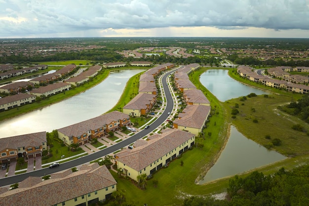 Vista aerea di case strettamente affollate in Florida club di vita chiusi con acqua del lago al centro case familiari come esempio di sviluppo immobiliare nelle periferie americane