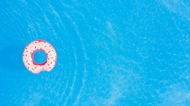 Vista aerea di grande ciambella rosa sullo sfondo della piscina