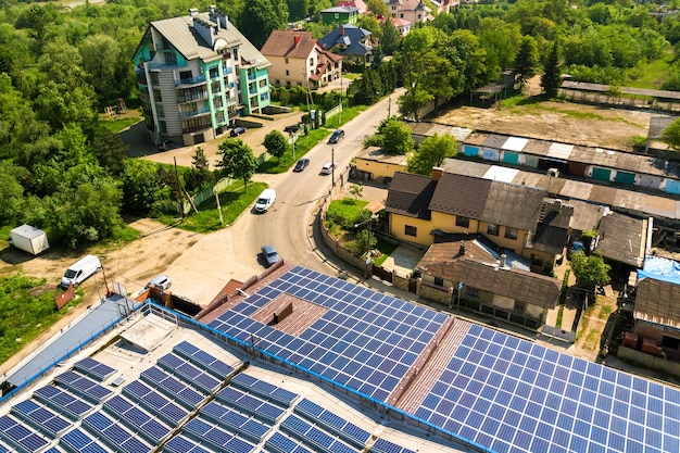 Vista aerea di molti pannelli solari fotovoltaici montati sul tetto di un edificio industriale.