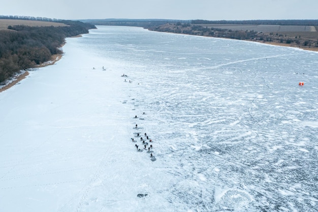 Vista aerea di molti pescatori sulla pesca invernale sul ghiaccio pesca pericolosa sull'inverno di ghiaccio sottile