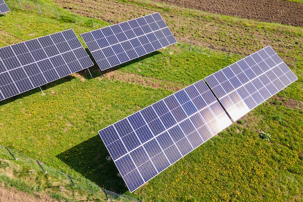 Vista aerea di pannelli solari fotovoltaici blu montati sul terreno del cortile per la produzione di elettricità ecologica pulita. Produzione del concetto di energia rinnovabile.