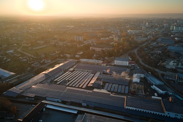 Vista aerea di pannelli solari fotovoltaici blu montati sul tetto di un edificio industriale per la produzione di elettricità ecologica verde Produzione di energia sostenibile