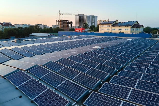 Vista aerea di pannelli solari fotovoltaici blu montati sul tetto di un edificio industriale per la produzione di elettricità ecologica verde Produzione di energia sostenibile