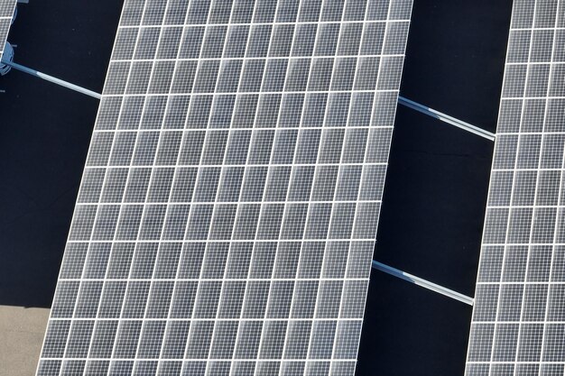 Vista aerea di pannelli solari fotovoltaici blu montati sul tetto di un edificio industriale per la produzione di elettricità ecologica verde Produzione di energia sostenibile