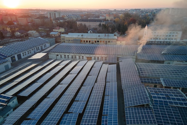 Vista aerea di pannelli solari fotovoltaici blu montati sul tetto di un edificio industriale per la produzione di elettricità ecologica verde Produzione di energia sostenibile