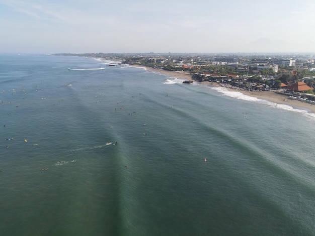 Vista aerea di persone che navigano sulle onde con le tavole da surf durante le vacanze a Bali Indonesia