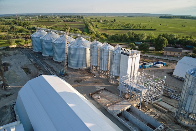 Vista aerea di silos ventilati industriali per lo stoccaggio a lungo termine di grano e semi oleosi Ascensore in metallo per l'essiccazione del grano in zona agricola