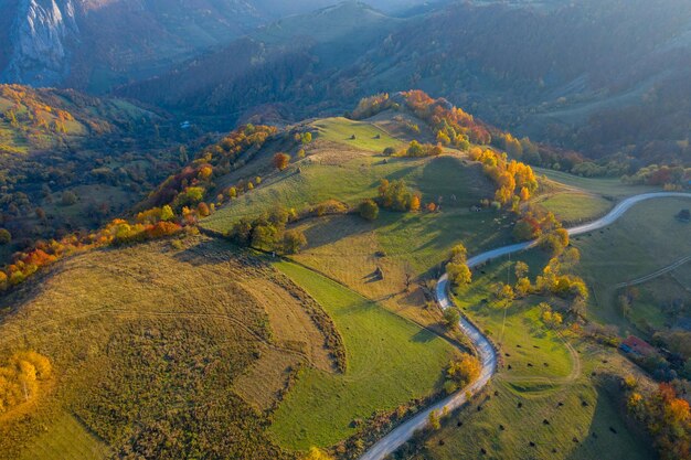 Vista aerea di un drone di una strada di terra in campagna in autunno