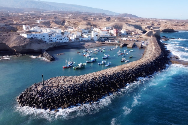 Vista aerea di un piccolo paese di pescatori con alcune barche colorate a Tajao, Tenerife, Isole Canarie.