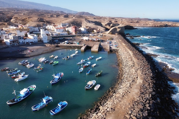 Vista aerea di un piccolo paese di pescatori con alcune barche colorate a Tajao, Tenerife, Isole Canarie.