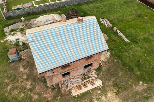 Vista aerea di una casa con mattoni a vista con struttura del tetto in legno in costruzione.