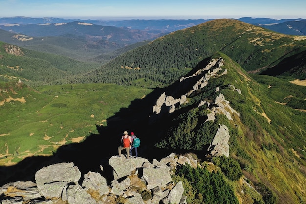 Vista aerea di una coppia di turisti con lo zaino in cima a una montagna